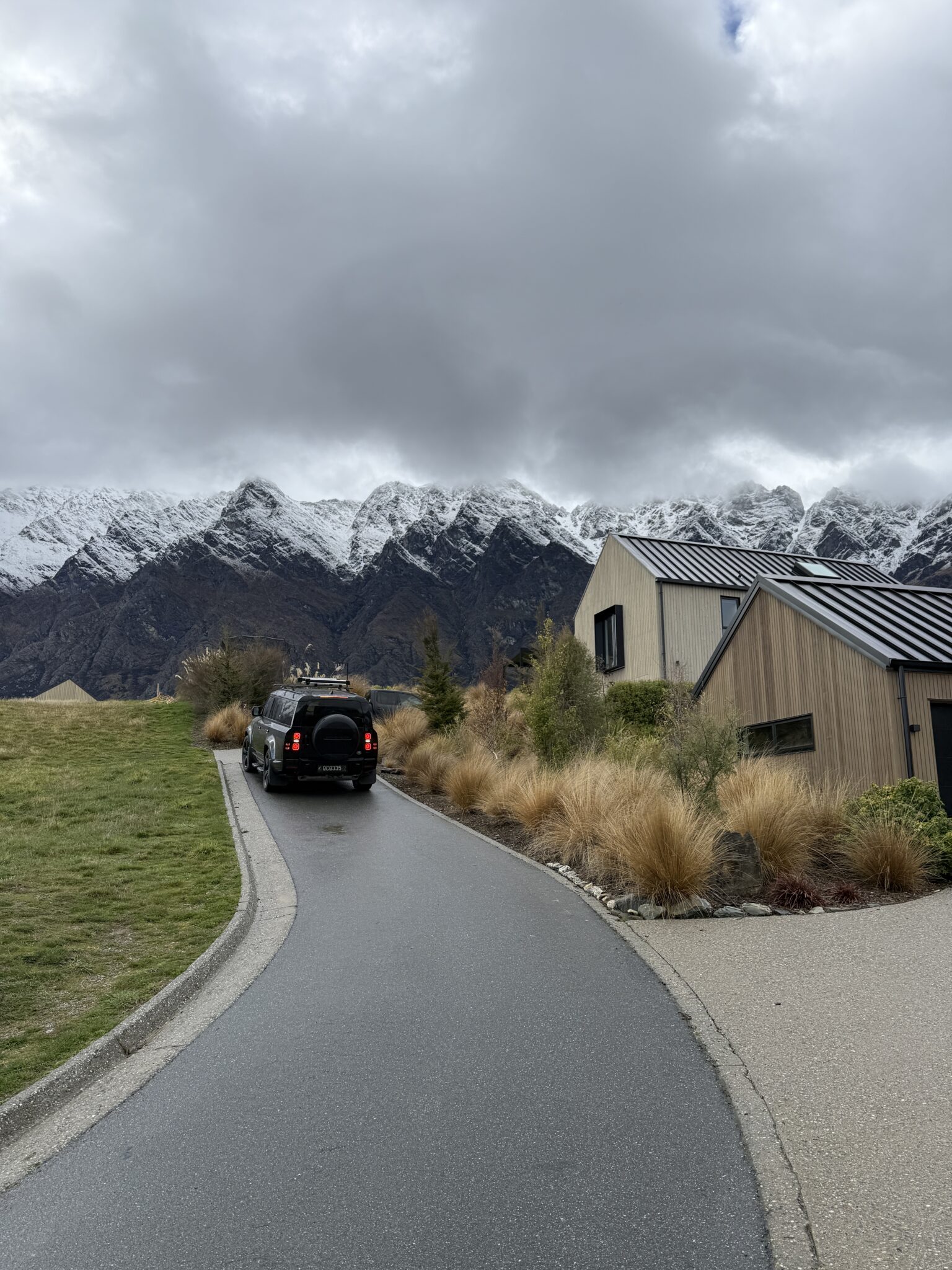 Land Rover Defender on a gravel road surrounded by New Zealand mountain scenery