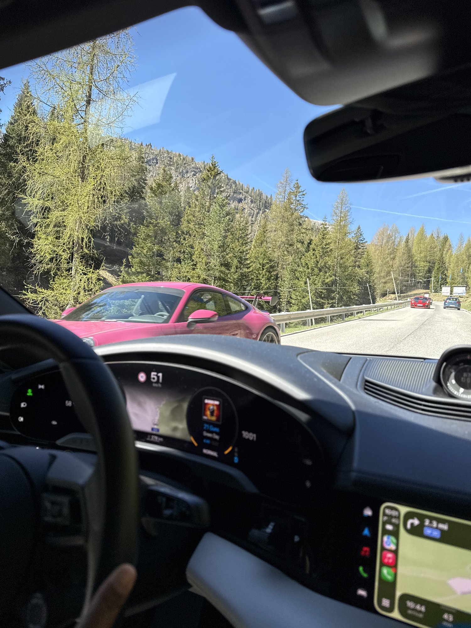 Pink Porsche 911 GT3 passing on a Dolomites mountain pass road